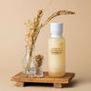 Glow Rice Moisturizer with rice bran water and vitamin C, displayed with dried rice stalks and grains on a wooden tray
