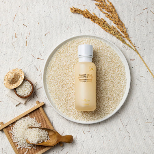 Glow Rice Moisturizer with rice bran water & vitamin C, surrounded by raw rice grains and stalks for natural K-beauty skincare