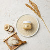 Glow Rice Cream with rice grains, rice stalks, and wooden spoon on textured background for K-Beauty skincare