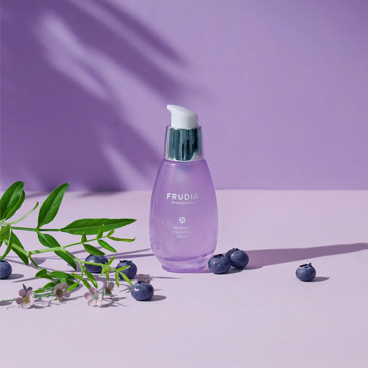 Frudia Blueberry Hydrating Serum bottle, vegan hyaluronic acid facial skincare product on purple background 