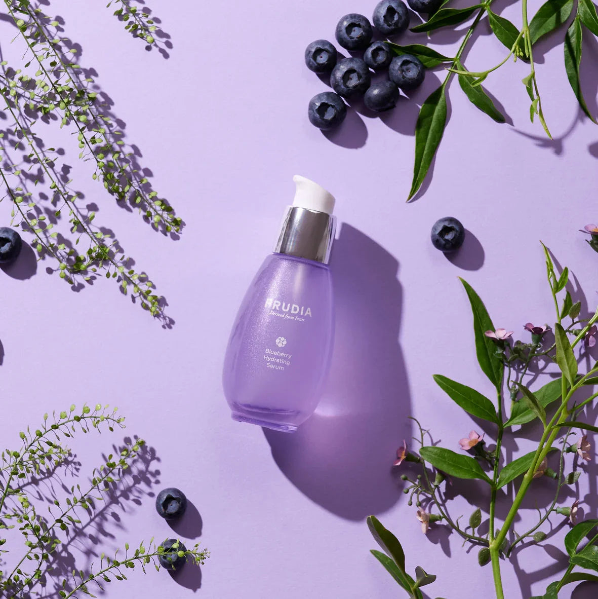 Frudia Blueberry Hydrating Serum bottle, vegan hyaluronic acid facial skincare product on purple background 