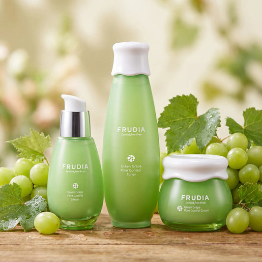 Frudia Green Grape Pore Control skincare set with serum, toner, and cream, surrounded by fresh grapes and leaves.